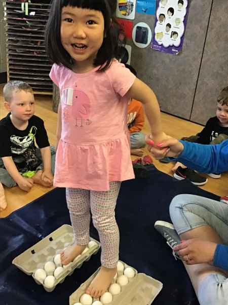 girl standing on a dozen of eggs and they are staying in tact